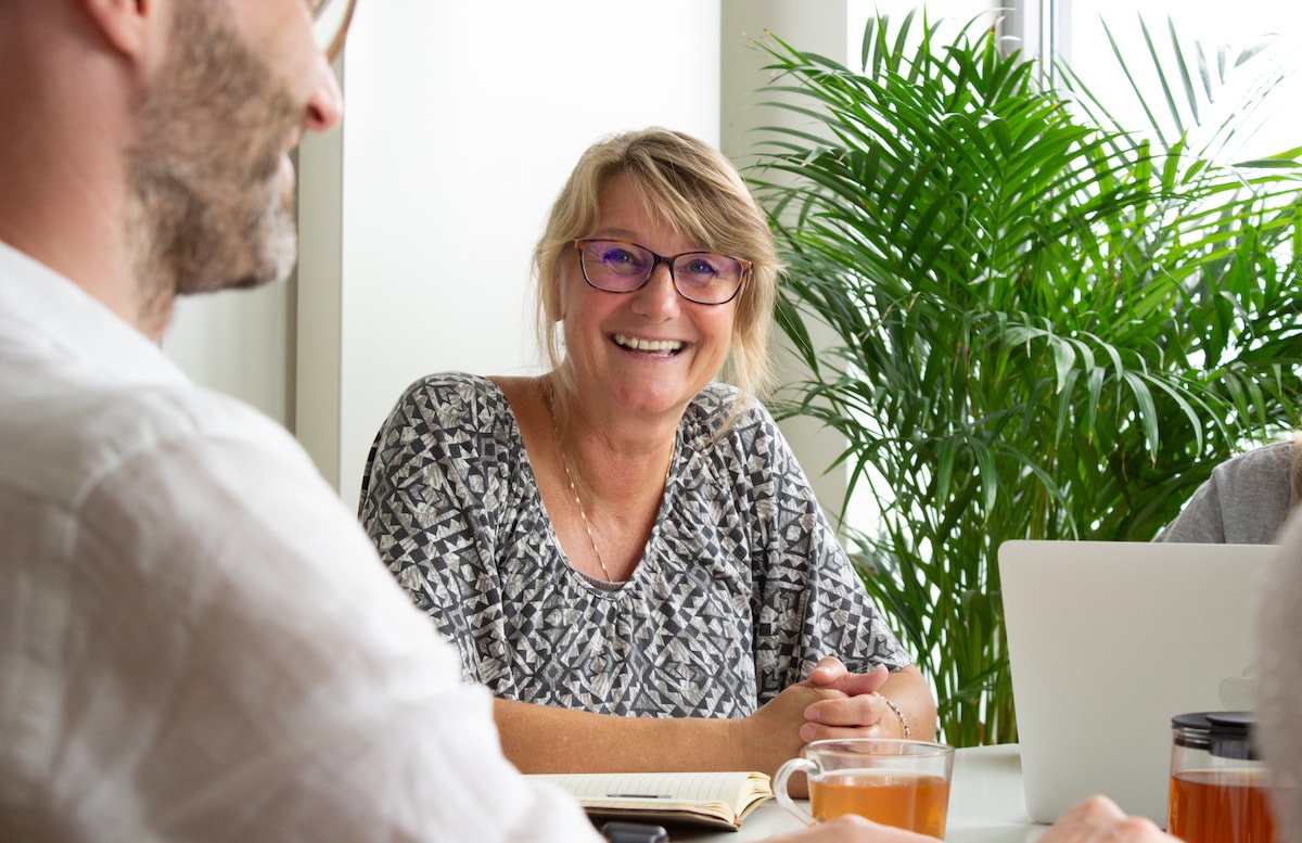 a photo showing a smiling woman in a meeting
