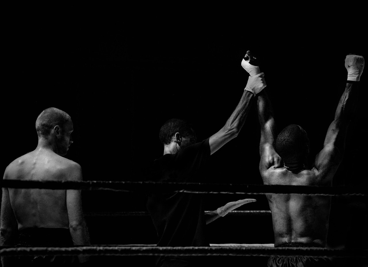 photograph picture of two boxers and a referee in the ring after a fight