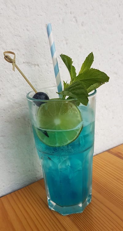 A Blue Lagoon cocktail with a lime.