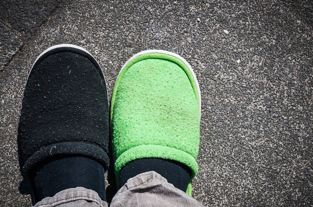 Picture of mismatching slippers on shoes.