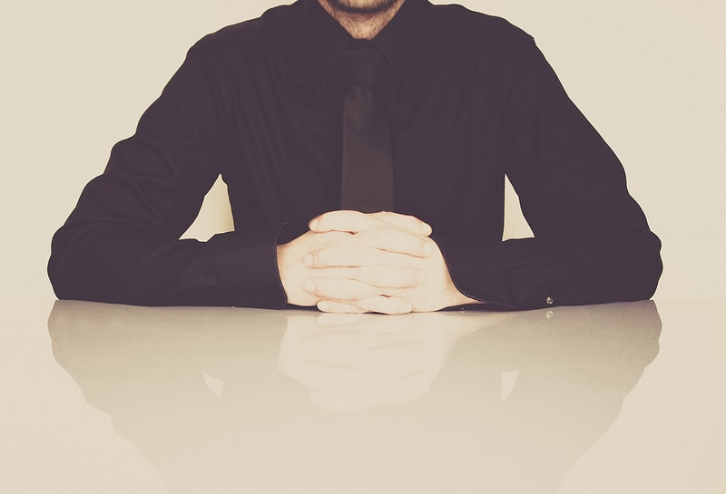 photograph picture of a man in a black shirt sitting at a table