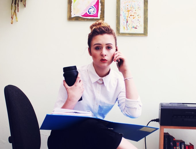 photograph picture of a woman in an office on the phone