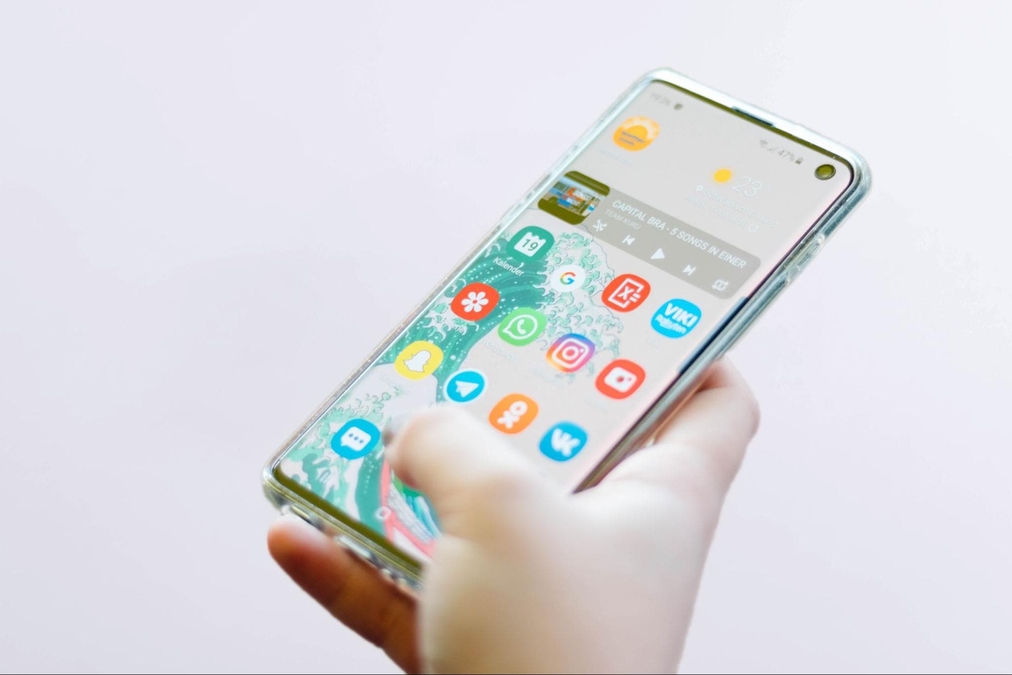 Eine Hand die ein Smartphone hält worauf Messaging-Apps zu sehen sind