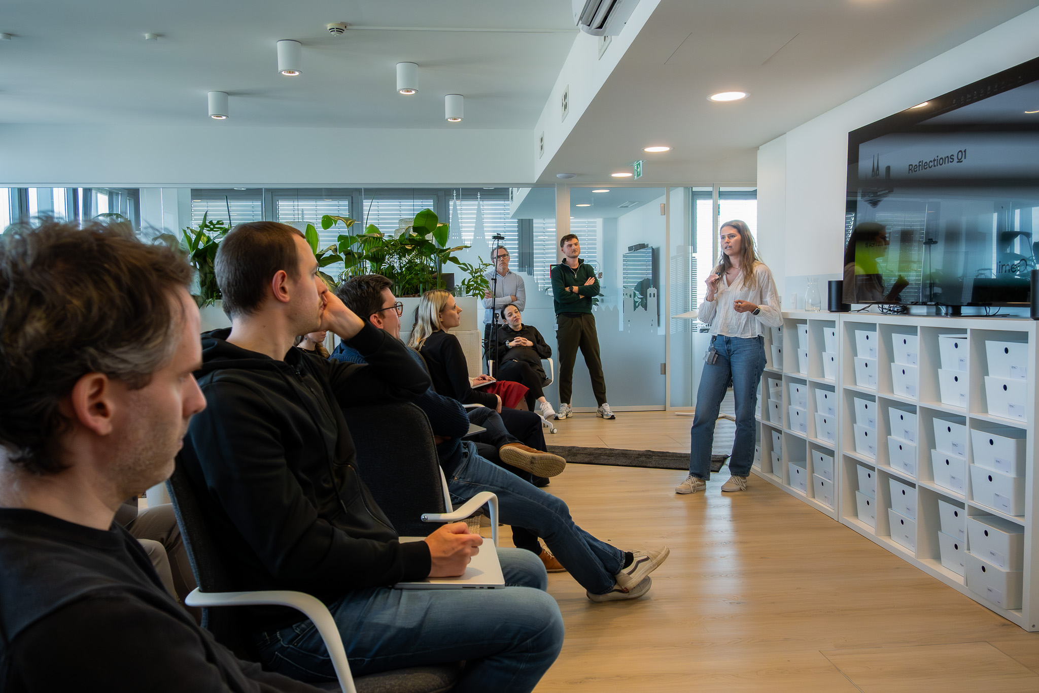 a woman presenting to a group of people seated in chairs in a well lit room
